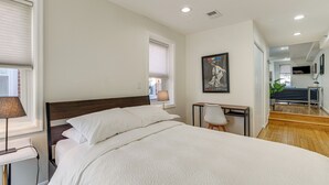 Une chambre d’hôtel moderne avec un grand lit, un bureau et une chaise.