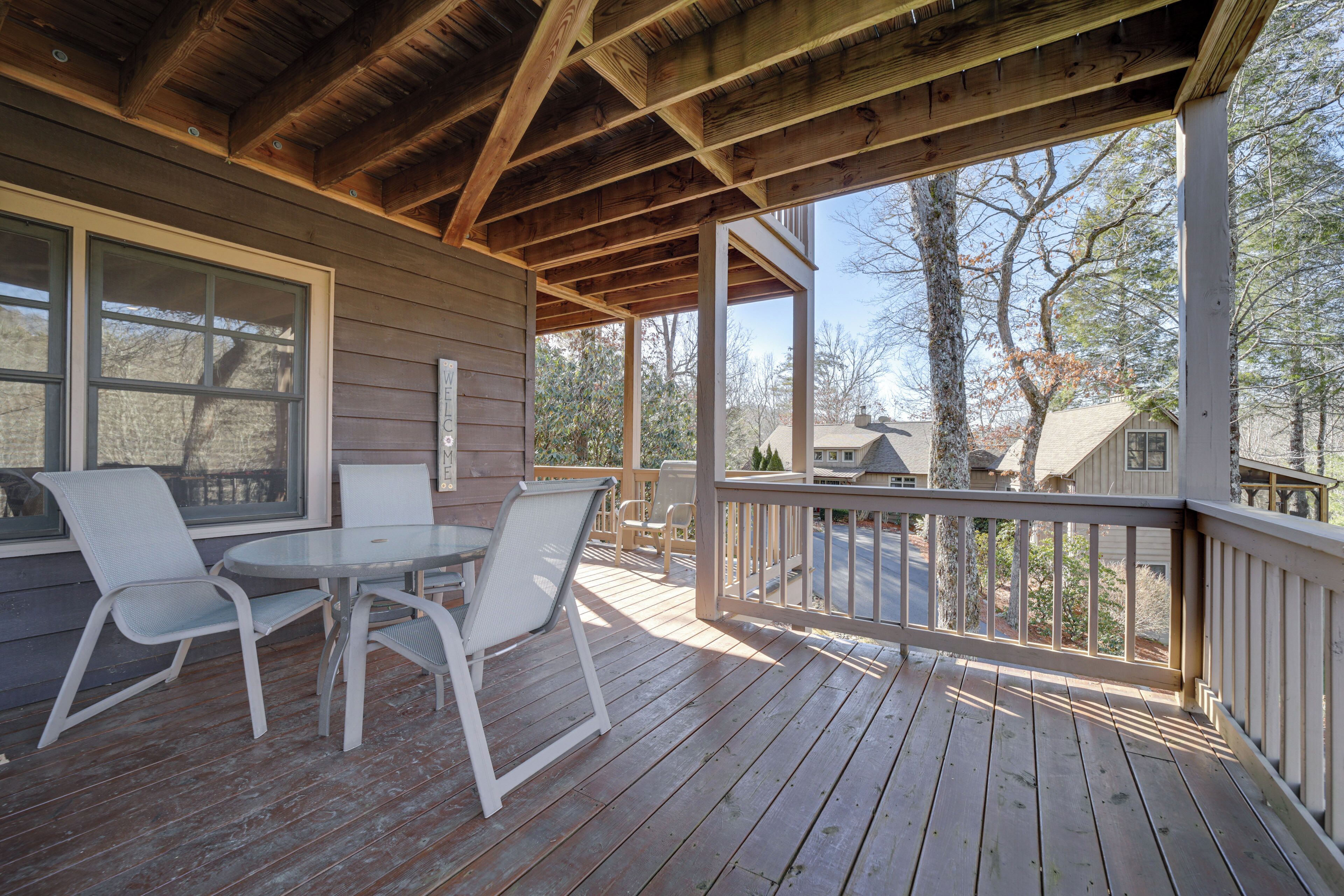 A wooden deck with a table and chairs, overlooking a residential area.
