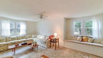 A living room with a sofa, a coffee table, a lamp, and a rug.