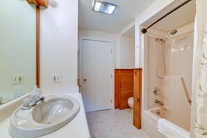 Bathroom features a sink, mirror, shower with glass door, and toilet.