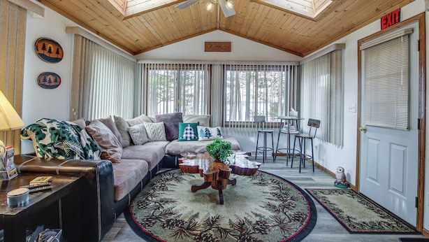 A cozy living room with a ceiling fan, a sofa, a coffee table, and a dining area with a chair and table. - Versatile Castle Rock Lake Home With Fire Pit! (Friendship)