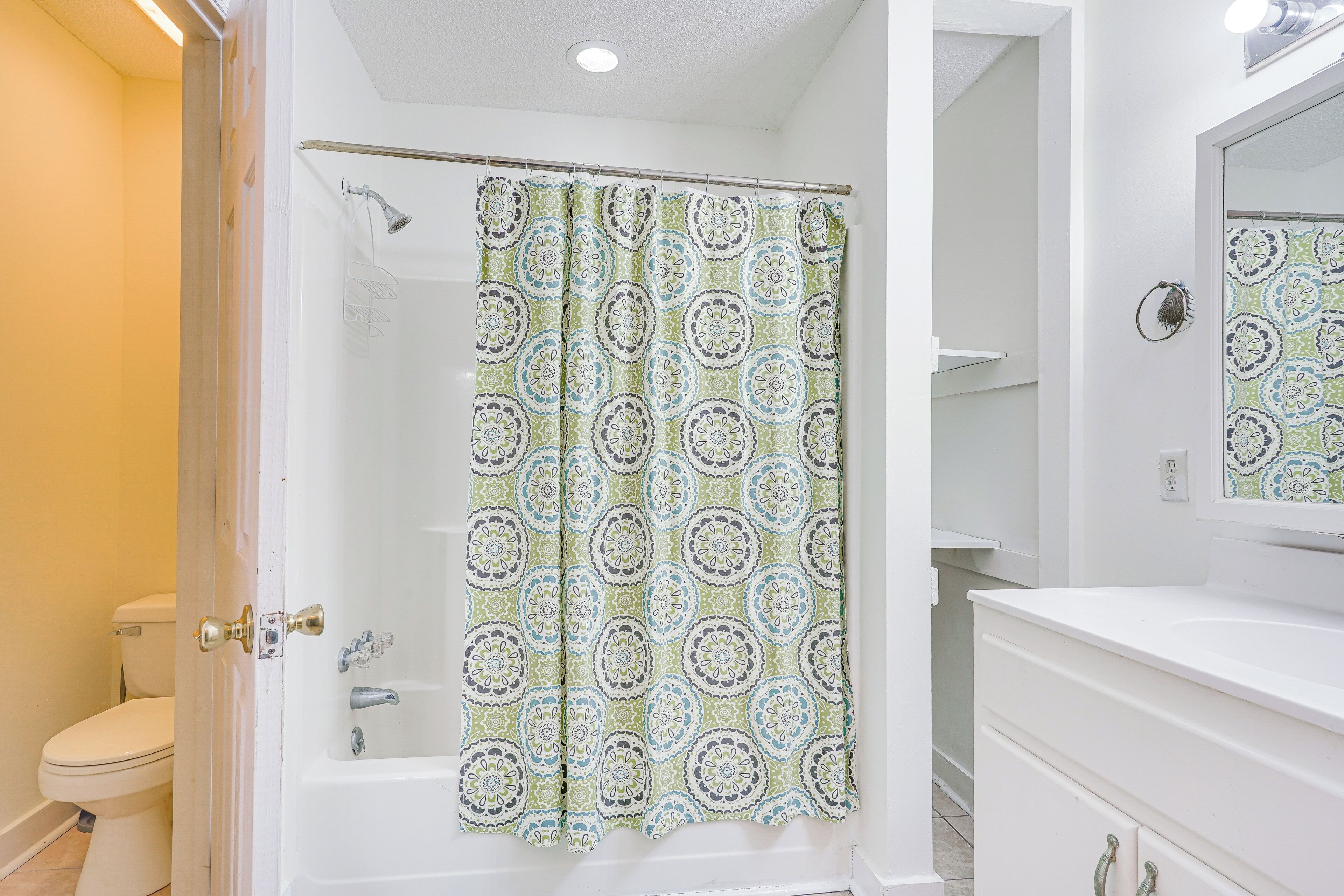 A bathroom with a shower, toilet, and sink.