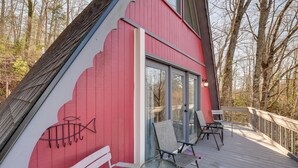 Un bâtiment rouge doté d’une terrasse, d’une porte vitrée et d’une fresque représentant des poissons.