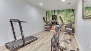 A home gym with a treadmill, stationary bike, and weights. - Cozy Inwood Apartment: History, Hiking & Wine! (Inwood)