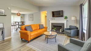 A living room with a sofa, armchairs, a coffee table, a fireplace, and a television. - Decatur Vacation Rental w/ Fenced Yard! (Decatur)