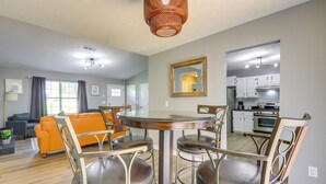 A modern living room with a round dining table, four chairs, a sofa, and a kitchen in the background. - Decatur Vacation Rental w/ Fenced Yard! (Decatur)