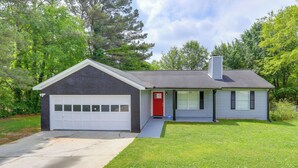 A single-story house with a garage, a red door, and a chimney. - Decatur Vacation Rental w/ Fenced Yard! (Decatur)