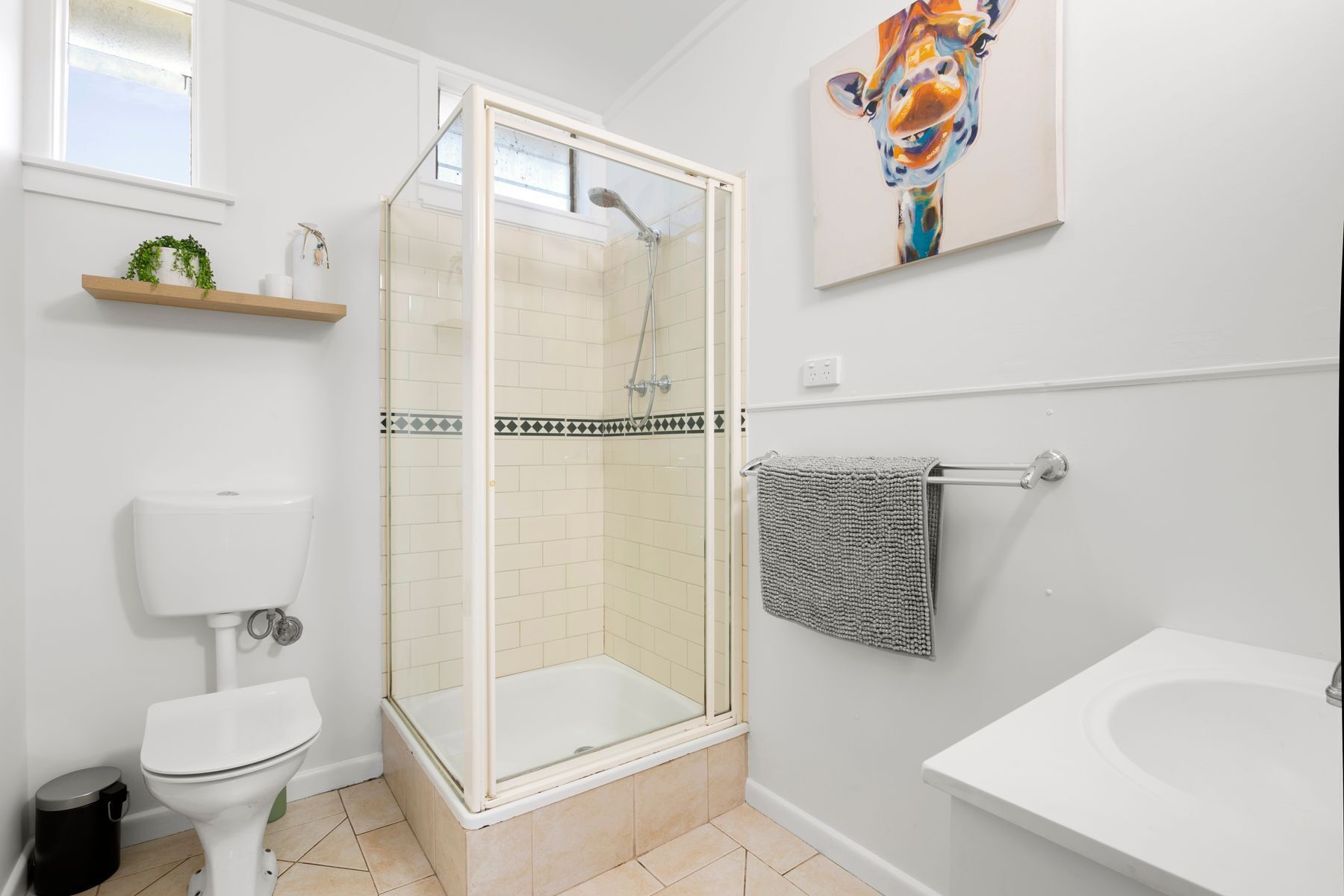 A modern bathroom with a glass-enclosed shower, a toilet, and a bathtub.