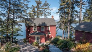 A red house with a chimney, surrounded by trees and a lake. - Lake Winnipesauke compound sleeps 22 in 13 bedrooms stunning sunset views (Alton Bay)