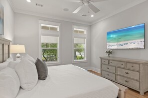 A bedroom with a bed, a dresser, a ceiling fan, and a painting of a beach. - The Gulf Pearl on 30A - 4B/4.5B Private Pool / 6-Seater Golf Cart (Santa Rosa Beach)