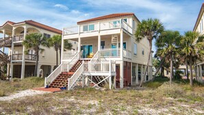 A beachfront hotel with a two-story structure, a central staircase, and balconies. - Dog-Friendly, Pool & Tennis Court, Hot Tub in Sunset Beach! (St. George Island)
