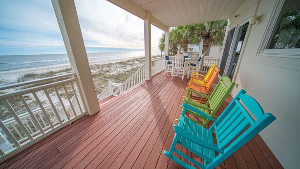 A wooden deck with a view of the beach and ocean. There are colorful chairs and a table. - Dog-Friendly, Pool & Tennis Court, Hot Tub in Sunset Beach! (St. George Island)