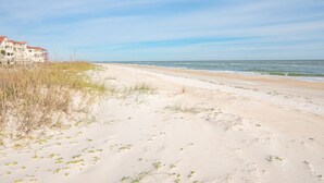 A beach with a building on the left. - Dog-Friendly, Pool & Tennis Court, Hot Tub in Sunset Beach! (St. George Island)