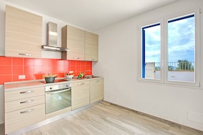 Een koelkast, een oven, een kookplaat, een koffiezetapparaat/waterkoker