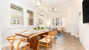 Una cocina moderna con una mesa de comedor de madera, sillas y una lámpara colgante.