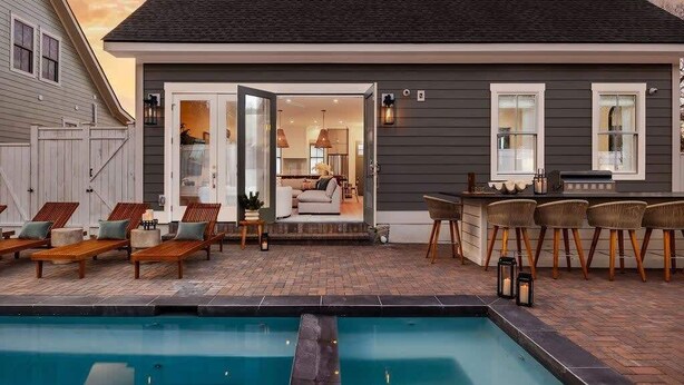 A modern house with a pool, outdoor seating, and a bar area. - Spacious Savannah Home | Pool, Spa & Greens (Savannah)