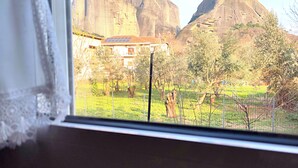 A window view of a house with a large rock formation in the background. - Kastraki House with a view (Kalabaka)