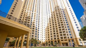 Un hôtel de grande hauteur, avec de nombreux étages, une cour intérieure et une pelouse bien entretenue.