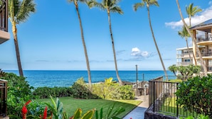 A resort with a view of the ocean, palm trees, and a well-maintained garden. - Kona Makai 1-103 Nearly Oceanfront, Ground Floor, No Stairs, Special Location (Kailua Kona)