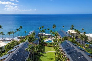 Un resort con paneles solares, piscina y vista al océano.