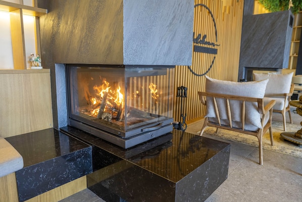 A modern living room with a fireplace, a sofa, and a coffee table.