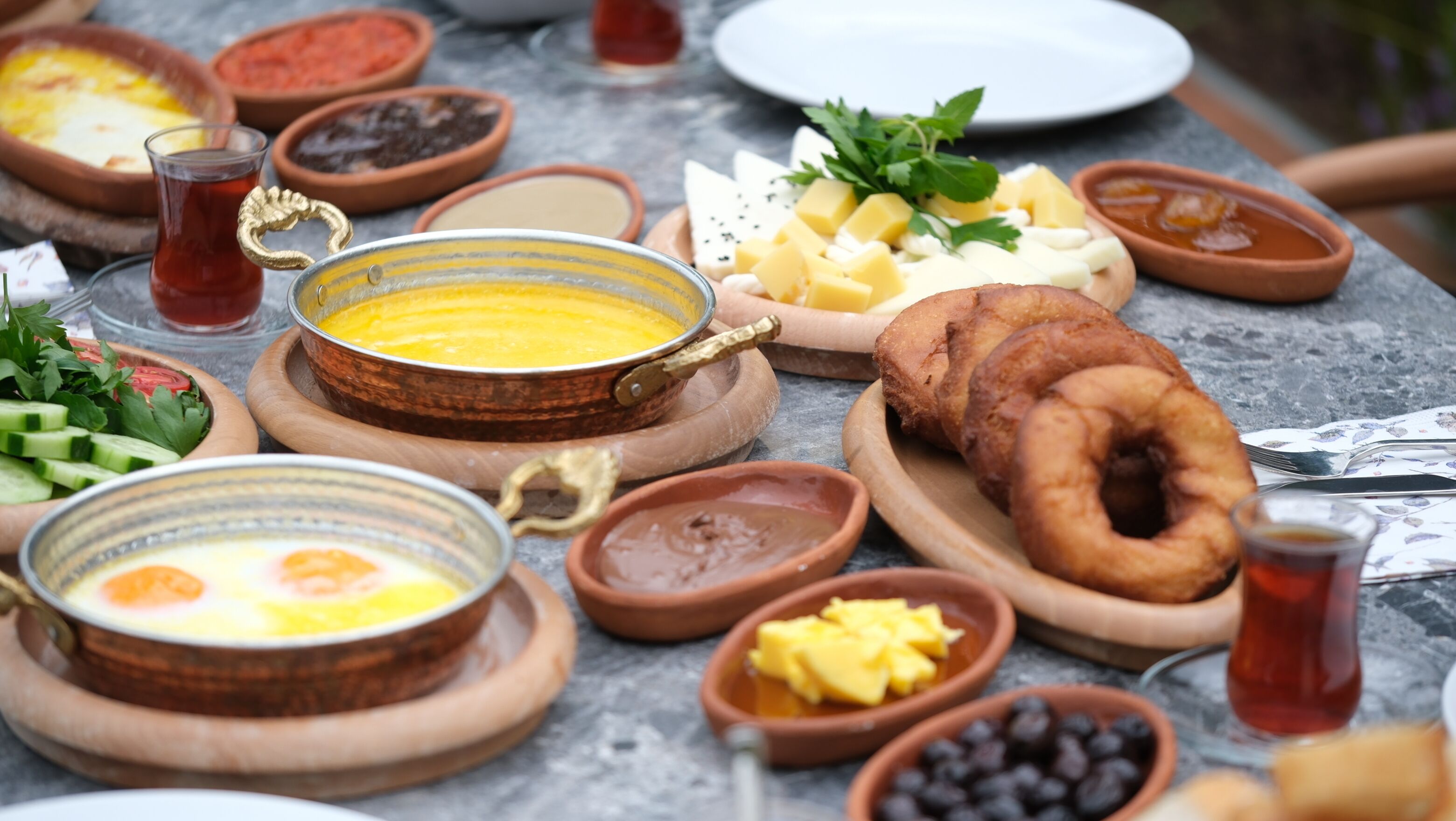 A table with various breakfast items including eggs, cheese, bread, and condiments.
