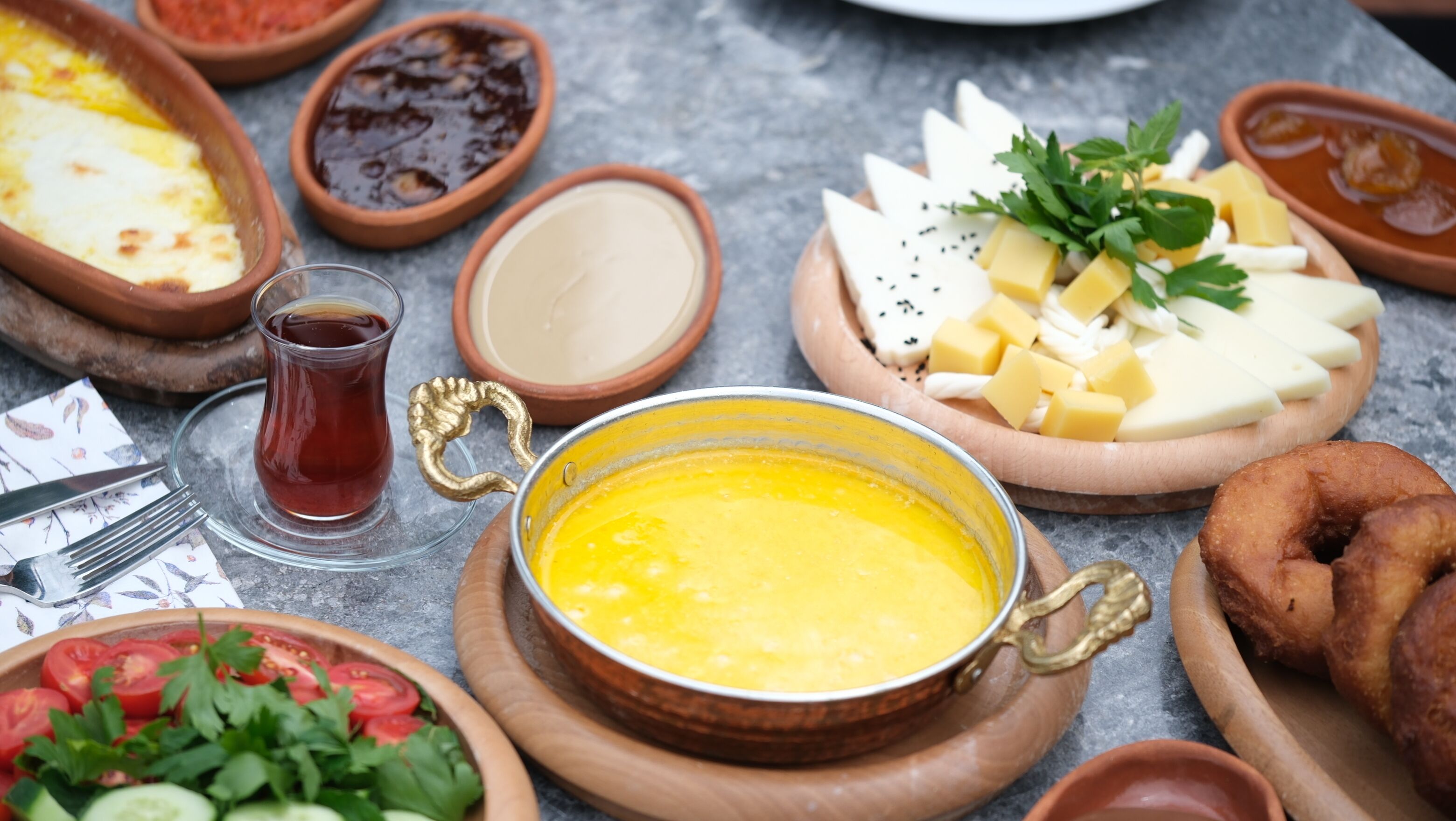 Diverse etenswaren, waaronder een kom gele soep, kaas, tomaten en brood.