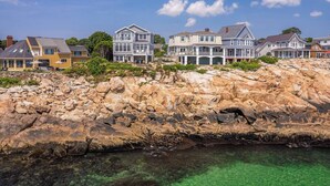 A coastal property with multiple houses, a rocky shoreline, and clear water. - Overlook Beach House #4- York Maine Beach Rental (York)