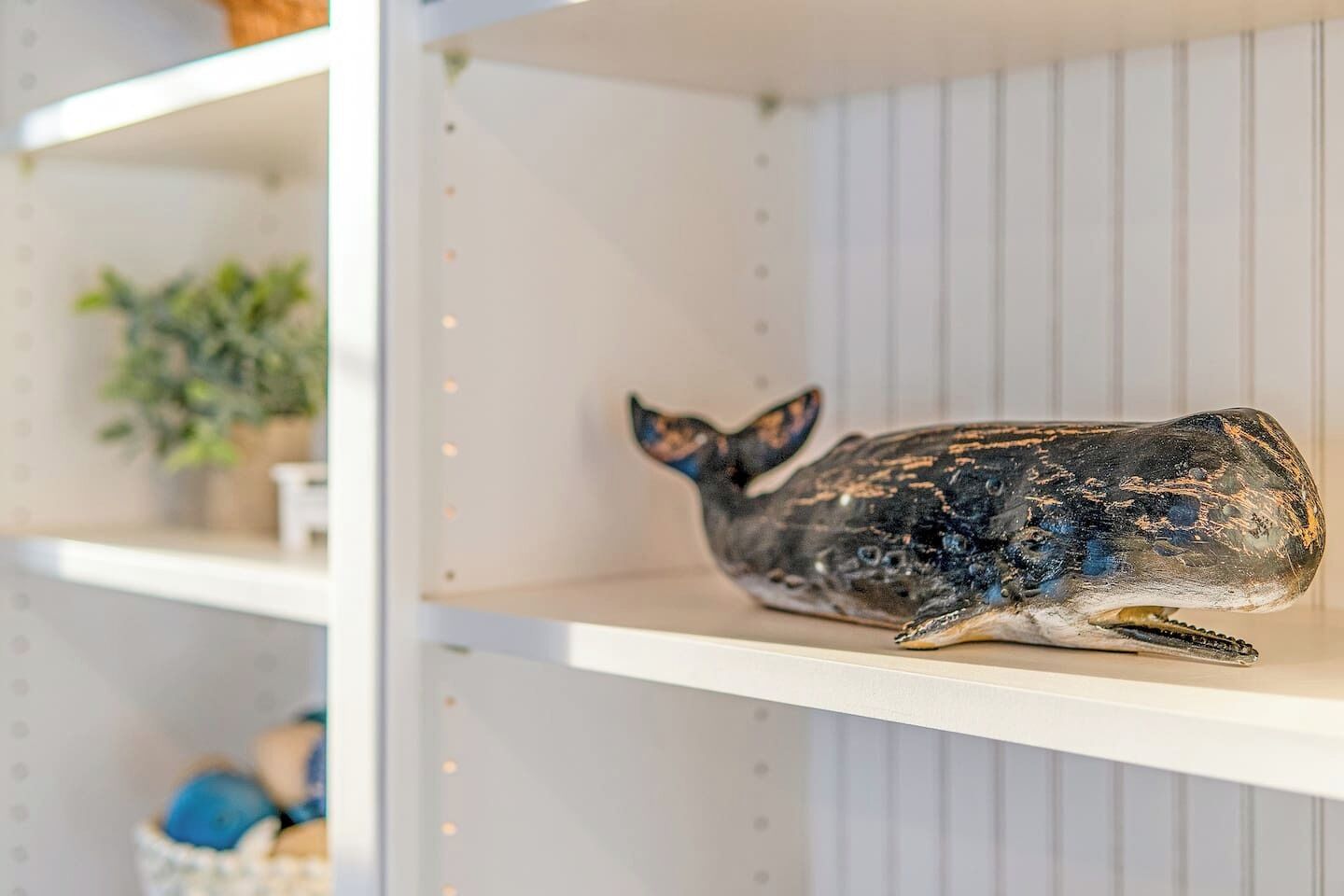 Una estantería con una escultura de ballena.