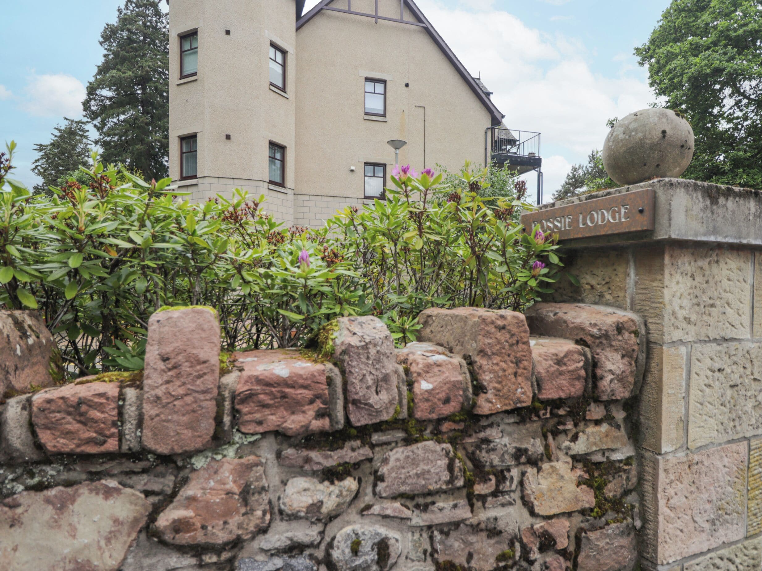 A stone wall with a sign reading "Fossil Lodge."