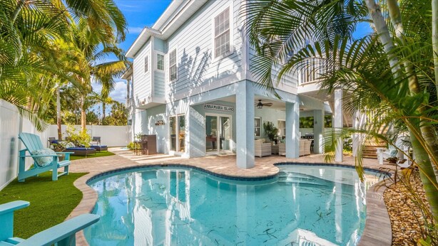 A pool surrounded by a white building with a sign reading "Anna Maria Island."