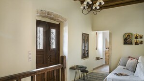 Ein gemütliches Zimmer mit einer Holztreppe, einem Sofa, einem kleinen Tisch und einem Spiegel.