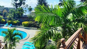 A swimming pool surrounded by palm trees and a wooden deck. - Reef Utopia Tobago Private Beautiful Villa,3mins Walk to Beach,Great Pool,Garden (Tobago)