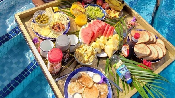 A poolside breakfast tray with various fruits, bread, and beverages. - Reef Utopia Tobago Private Beautiful Villa,3mins Walk to Beach,Great Pool,Garden (Tobago)