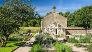 A stone building with a large garden, a greenhouse, and a pathway. - 4 bedroom accommodation in Broughton, near Skipton (Broughton, near Skipton)