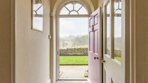 A hallway leading to a door with a view of a stone wall and grassy area outside. - 4 bedroom accommodation in Broughton, near Skipton (Broughton, near Skipton)