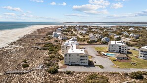 A coastal residential area with beachfront properties, a boardwalk, and a swimming pool. - Point Emerald A-205, Oceanfront Condo in Emerald Isle, NC! (Emerald Isle)