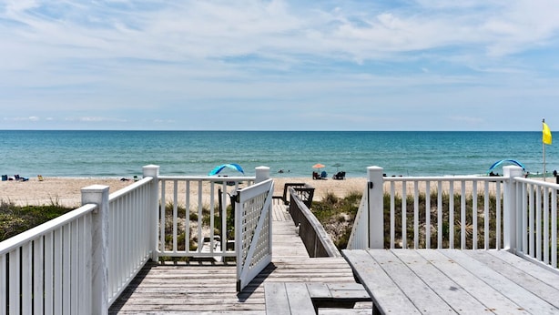 A wooden boardwalk leading to a beach with a clear view of the ocean. - Red Roof Cottage East, Oceanfront Duplex in Emerald Isle, NC! (Emerald Isle)