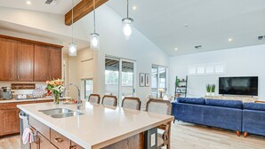Una cocina moderna con armarios de madera, una isla grande e iluminación colgante.