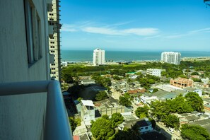 A high-rise building with a view of the ocean and other buildings.