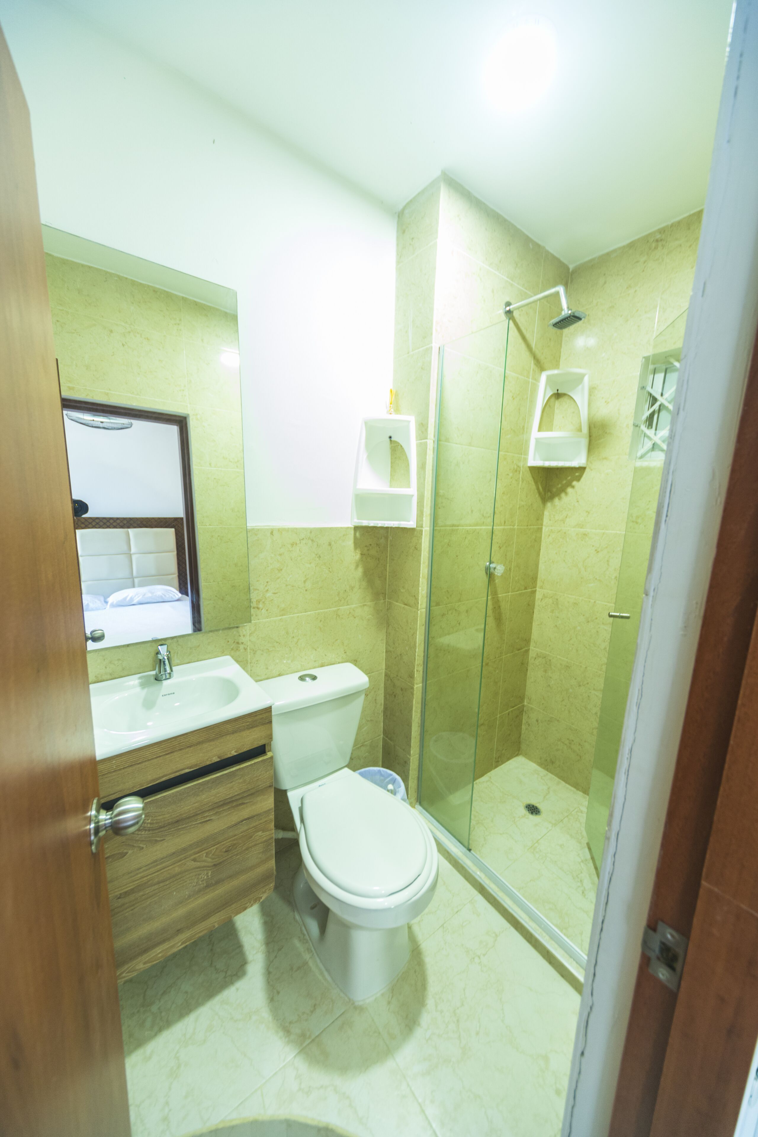 A bathroom with a sink, toilet, and glass-enclosed shower.