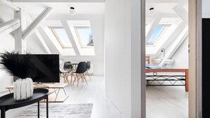 Ein modernes Interieur mit Essbereich, Fernseher und Schlafzimmer mit Oberlichtern.