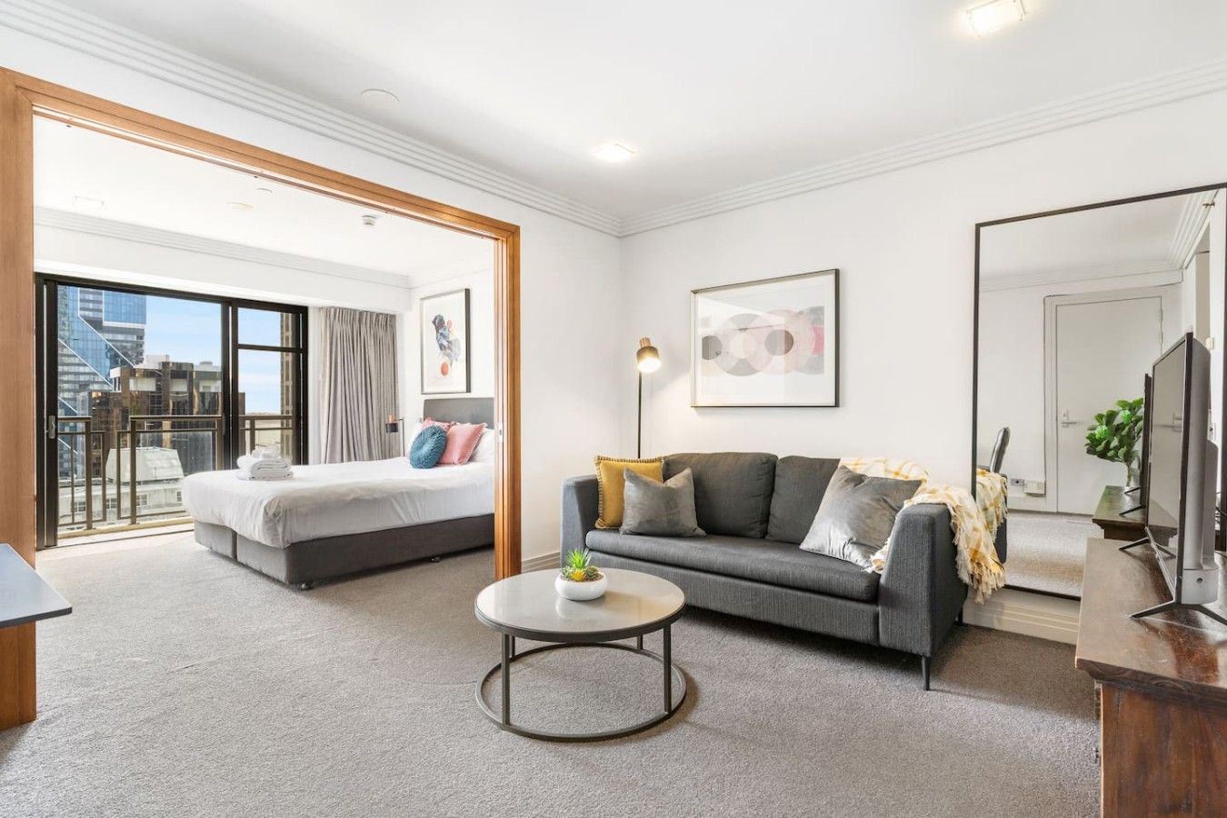 Ein modernes Hotelzimmer mit Bett, Sofa und einem kleinen Couchtisch.