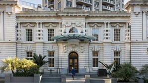 A large, historic building with a grand entrance, multiple windows, and a central clock. - Stunning City Views - w Pool&Gym (Auckland)