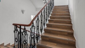 Eine Treppe mit aufwendiger schwarzer Geländer und Holzstufen.