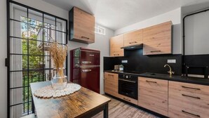 Eine moderne Küche mit Holzausstattung, einer schwarzen Arbeitsplatte und einem eingebauten Backofen.