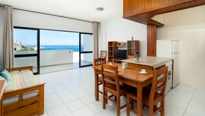 A modern kitchen with a dining area, a washing machine, and a large window with a view of the sea. - Praia da Rocha Wonder w/ Balcony by LovelyStay (Praia da Rocha)