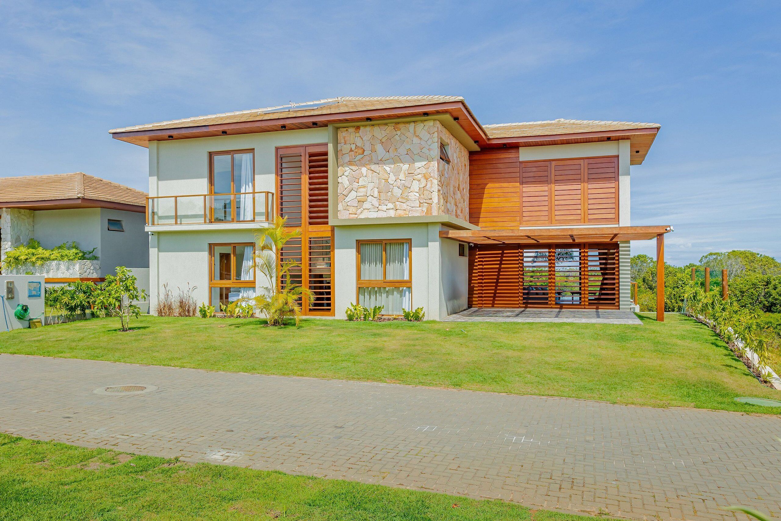 A modern two-story house with a stone facade, large windows, and a covered porch.