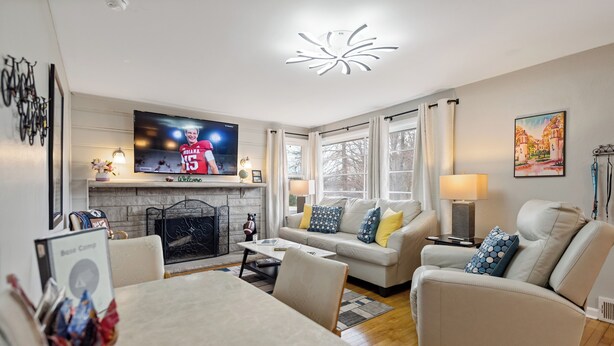Una sala de estar moderna con chimenea, televisor y comedor.
