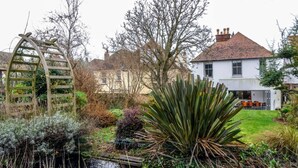 A garden with a pond, a wooden ladder, and a white house in the background. - Detached Edwardian Villa with Garden & Parking (Broadstairs)